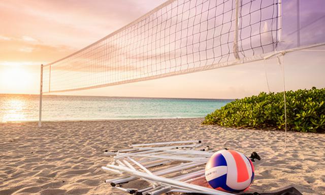 Portable beach volleyball net and ball set beside a North Palm Beach shoreline