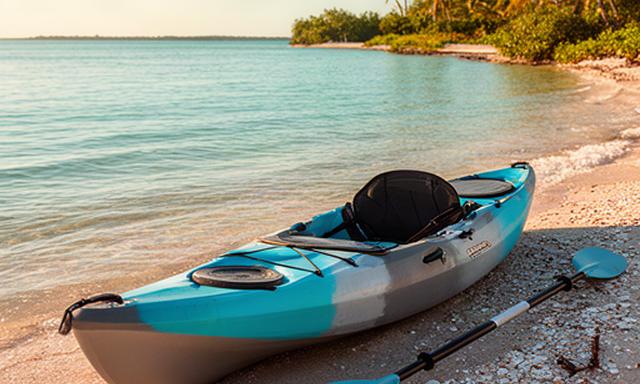 Recreational kayak and adjustable paddle on a sunny South Florida shoreline